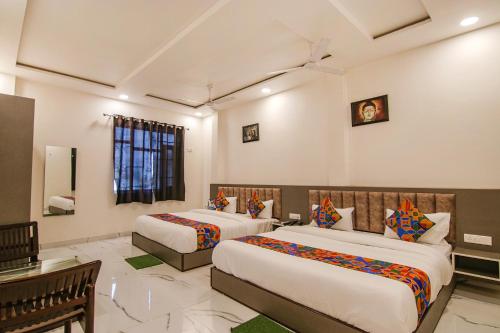 a hotel room with two beds and a desk at FabHotel Aryan Grand in Amritsar