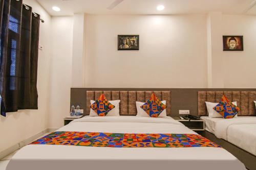 a bedroom with two beds and two pictures on the wall at FabHotel Aryan Grand in Amritsar