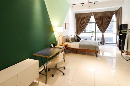 a bedroom with a bed and a desk and a green wall at 3Towers @ KL City Centre in Kuala Lumpur