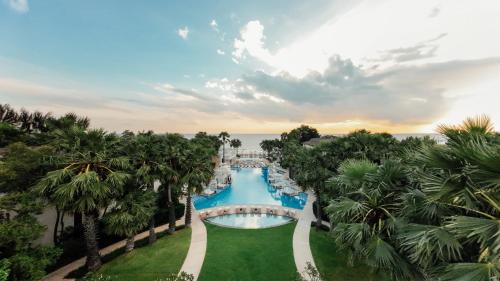 einen Luftblick auf einen Pool mit Palmen des Resorts in der Unterkunft InterContinental Hua Hin Resort, an IHG Hotel in Hua Hin