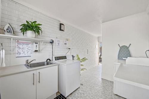 a white kitchen with a sink and a counter at Pottsville Beach Motel in Pottsville