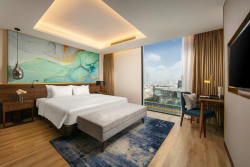 a hotel room with a bed and a large window at Mövenpick Living West Hanoi in Hanoi