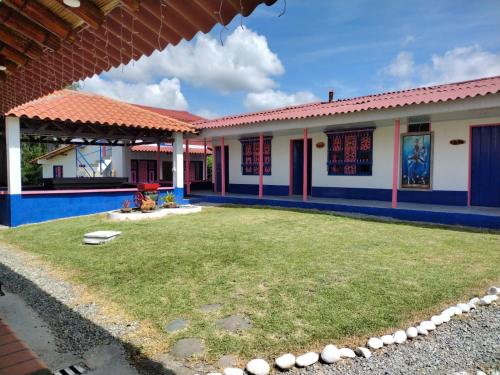 a house with a yard in front of it at FINCA HOTEL LA BONITA BY LA MACORINA in Quimbaya