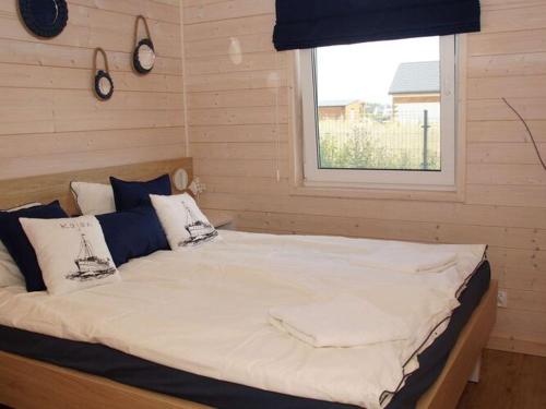 a large bed in a room with a window at Comfortable holiday cottages, Mielenko in Mielenko