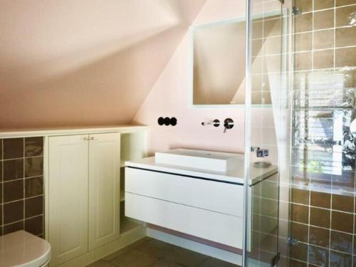 Un baño con lavabo y ducha de cristal. en Wohnung 4 Personen in Nieblum, en Nieblum