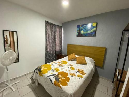 1 dormitorio con 1 cama con manta amarilla y blanca en Departamento entero Toluquilla HP/VFG/Iteso, en Guadalajara