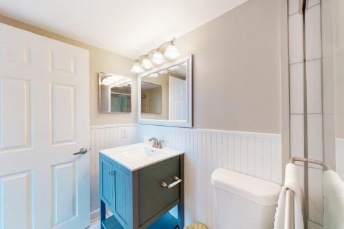 ein Badezimmer mit einem Waschbecken, einem WC und einem Spiegel in der Unterkunft Golden Sands 618 in Ocean City