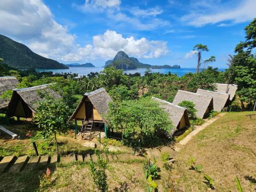 an aerial view of a village with thatched roofs at Forest Camp El Nido in El Nido