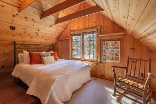 a bedroom with a bed and a chair in a cabin at Coziest Cabin in Tahoe w Stone Fireplace Comfy Beds Close to Slopes & Lake in Carnelian Bay