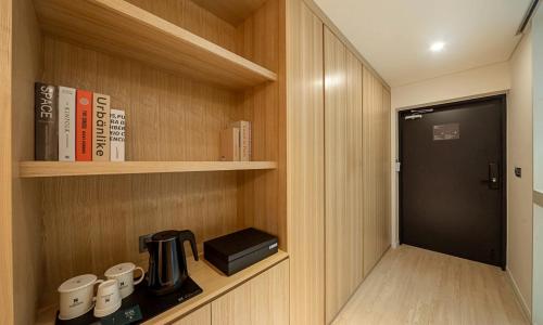 a cupboard with a coffee maker and books on it at Pohang Hotel Noblion in Pohang