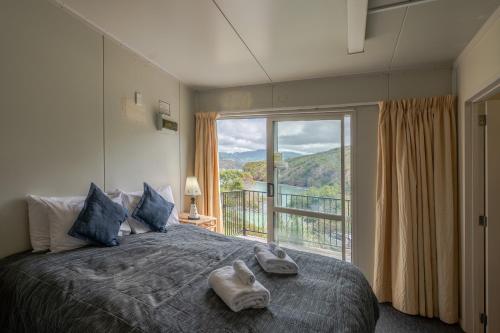 een slaapkamer met een groot bed met handdoeken erop bij Lushingtons Bay - Takamatua in Akaroa