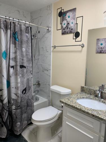 La salle de bains est pourvue de toilettes et d'un rideau de douche. dans l'établissement Blue Ivey Estates - 5 miles from Ft. Moore, à Columbus