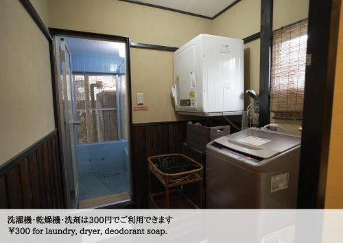 a small kitchen with a sink and a refrigerator at Hostel Knot in Izu