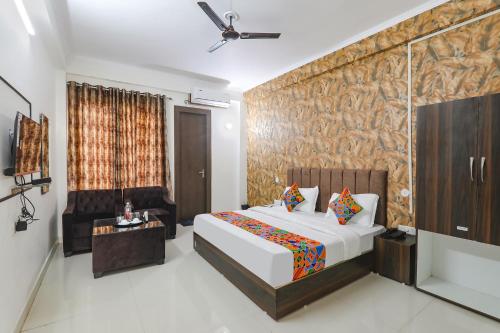 ein Hotelzimmer mit einem Bett und einem TV in der Unterkunft FabHotel The Villa I in Prayagraj