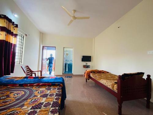 a bedroom with two beds and a ceiling fan at MISTY COORG GREENS in Madikeri