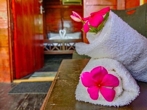 Una toalla con flores sentada en una mesa. en Ceylon Amigos Eco Resort, en Sigiriya