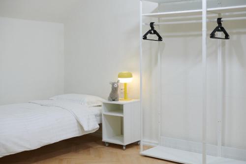 a bedroom with a bed and a lamp on a night stand at Lama Hostel in Ivano-Frankivsʼk
