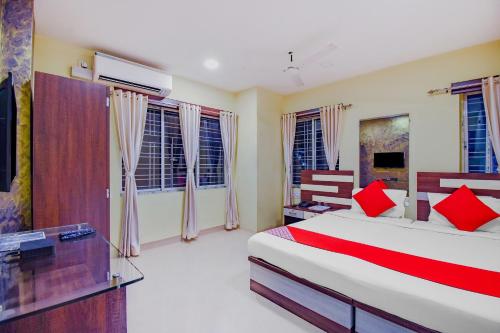 a bedroom with a large bed with red pillows at OYO Tranquil Stay in Ālīpur