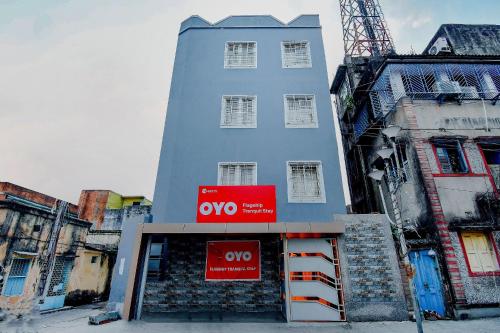 a tall blue building with a sign in front of it at Hotel O Tranquil Stay in Kolkata