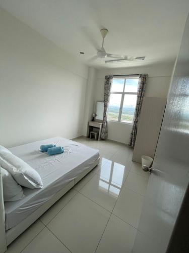 a white bedroom with a bed and a window at Rumah Puteh Homestay in Ipoh