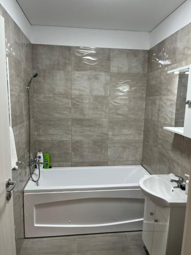a bathroom with a white tub and a sink at Pollux Residence Militari ap 158 in Dudu