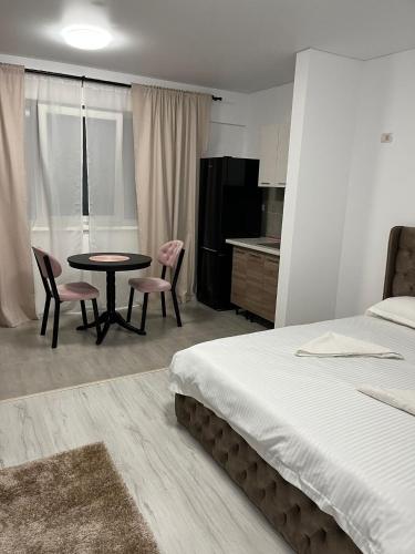 a bedroom with a bed and a table and chairs at Pollux Residence Militari ap 158 in Dudu