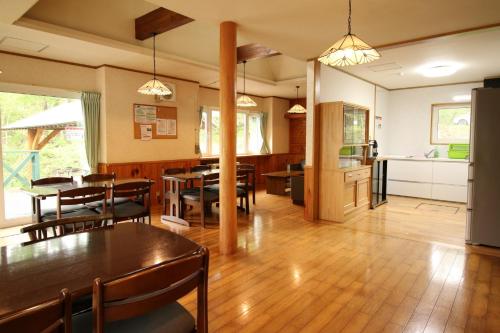 a dining room with tables and chairs and a kitchen at Cottage All Resort Service / Vacation STAY 8435 in Inawashiro