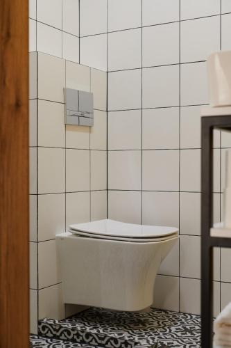 a white tiled bathroom with a tub on a floor at Lama Hostel in Ivano-Frankivsʼk