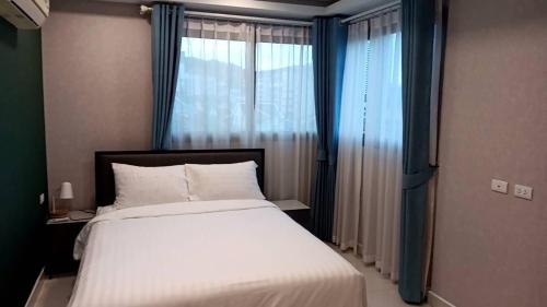 a bedroom with a bed and a large window at Arcadia Beach Continental by Saowanee in Pattaya South