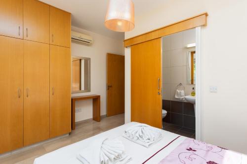 een slaapkamer met een bed en een badkamer bij Villa Panorama Tria in Droushia