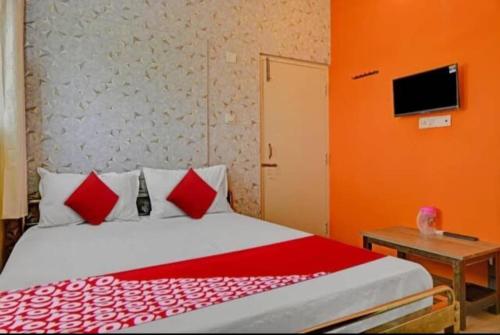 1 dormitorio con 1 cama con almohadas rojas y blancas en OYO Flagship Hotel Diamond Palace, en Kumbalgod