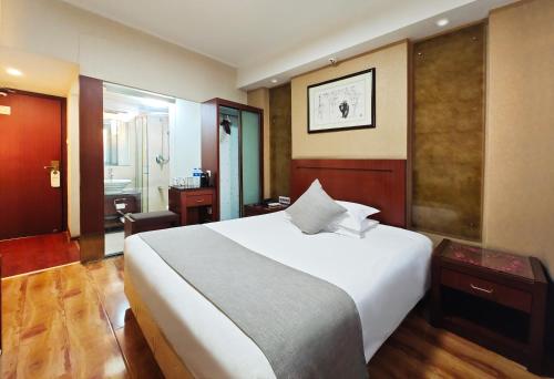 a bedroom with a large white bed and a bathroom at Hangzhou Bokai Westlake Hotel in Hangzhou