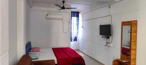 Habitación pequeña con cama y TV. en OYO Flagship Heaven Stay, en Chennai