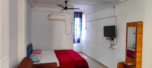 Kleines Zimmer mit einem Bett und einem TV in der Unterkunft OYO Flagship Heaven Stay in Chennai
