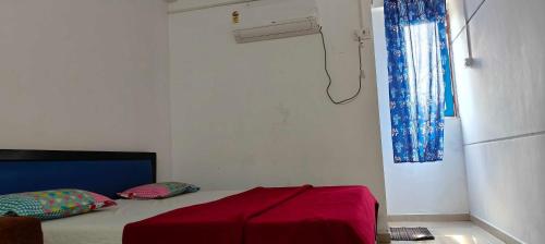 sypialnia z łóżkiem z czerwonym kocem i oknem w obiekcie OYO Flagship Heaven Stay w mieście Ćennaj