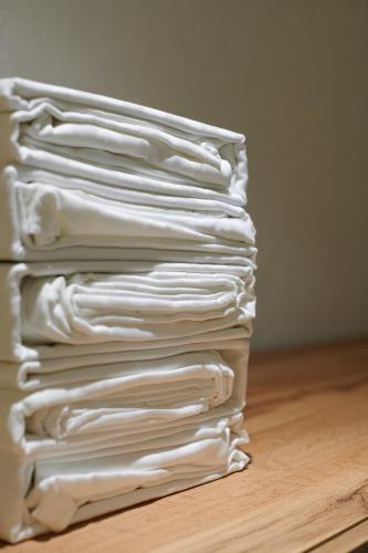 a stack of white shirts sitting on a wooden floor at Lama Hostel in Ivano-Frankivsʼk