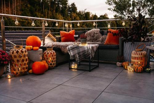 a patio with a bed and a table with pumpkins at Apartmany pod Pustevnami in Prostřední Bečva
