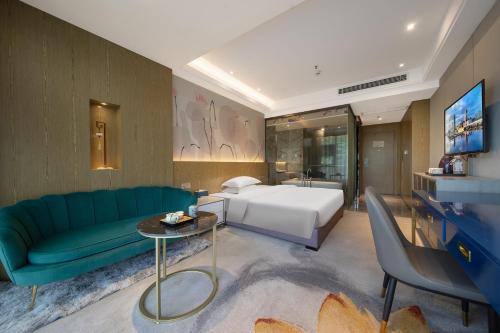 a living room with a green couch and a bed at Guangzhou Yunzhu Hotel in Guangzhou