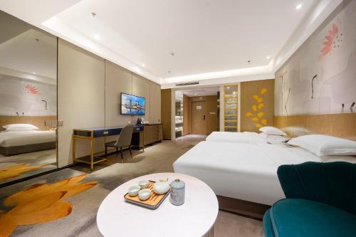 a hotel room with a large bed and a desk at Guangzhou Yunzhu Hotel in Guangzhou