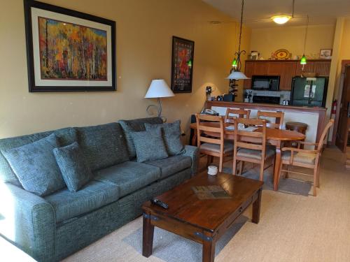 a living room with a blue couch and a table at Stunning at Solitude, Steps from Chair Lift, East #103 in Brighton