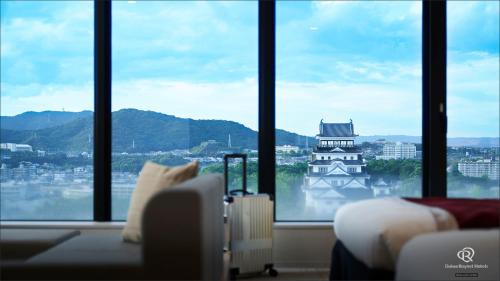 een kamer met een groot raam met uitzicht op een gebouw bij Daiwa Roynet Hotel Fukuyama Ekimae in Fukuyama