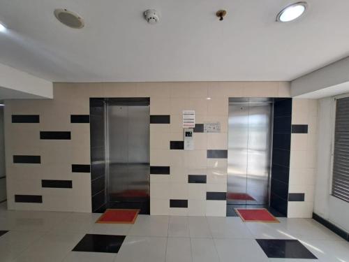 due ascensori nella hall con piastrelle bianche e nere di OYO 93366 Apartement Grand Sentraland By Rai Property a Jaken 1