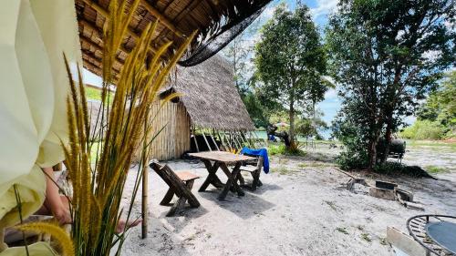 una mesa de picnic y sillas fuera de una cabaña en Green smile camping and private beach, en Krabi
