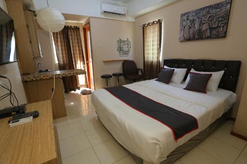 ein Schlafzimmer mit einem großen Bett in einem Zimmer in der Unterkunft Capital O 93372 Aurora Residence in Tangerang
