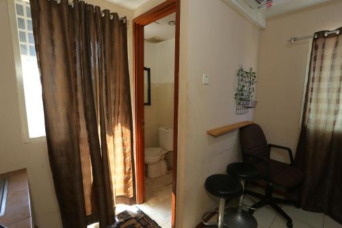 ein Bad mit einem WC, einem Stuhl und einem Fenster in der Unterkunft Capital O 93372 Aurora Residence in Tangerang