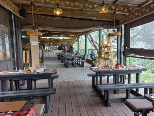 a restaurant with wooden tables and benches on a deck at Maroela Guest Lodge in Thabazimbi