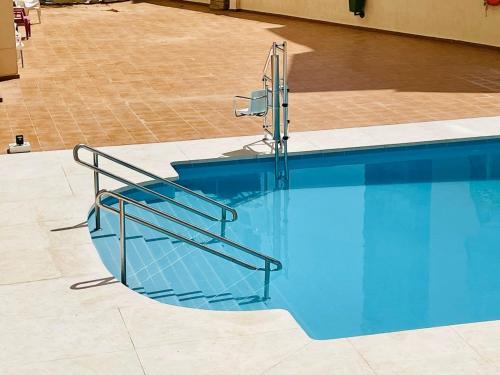 a swimming pool with a metal stair railing next to it at Luxury loft with in the centre in Torremolinos
