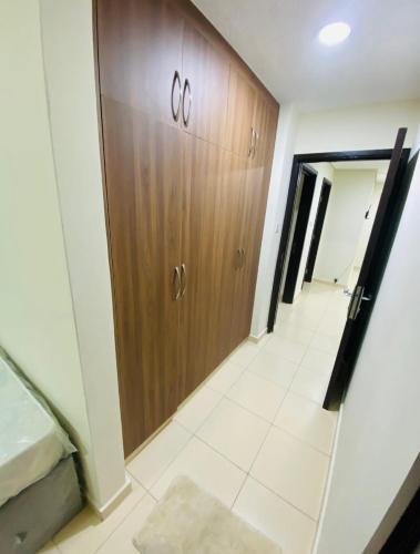 korytarzem pokoju z drewnianymi drzwiami w obiekcie Blessing house w Dubaju