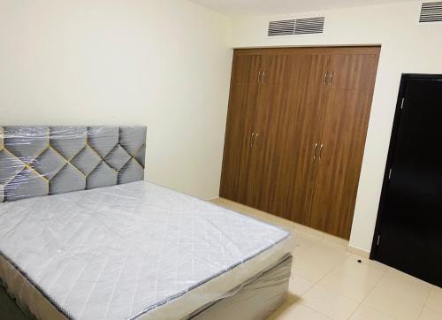 1 dormitorio con 1 cama y armarios de madera en Blessing house, en Dubái