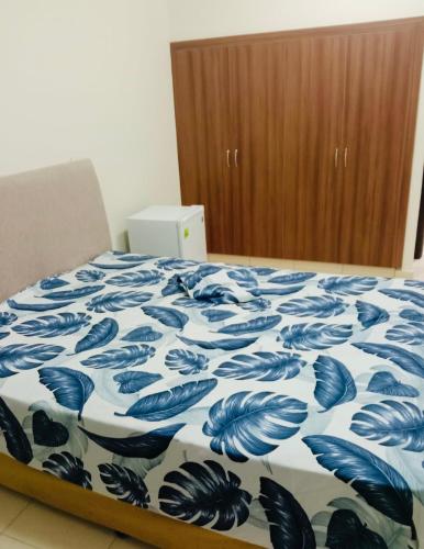 a bedroom with a bed with a blue and white blanket at Blessing house in Dubai